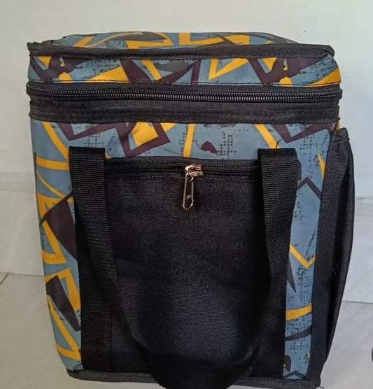 ReefyBags insulated lunch tote with a grey and yellow geometric print, black handles, and a front zipper pocket.
